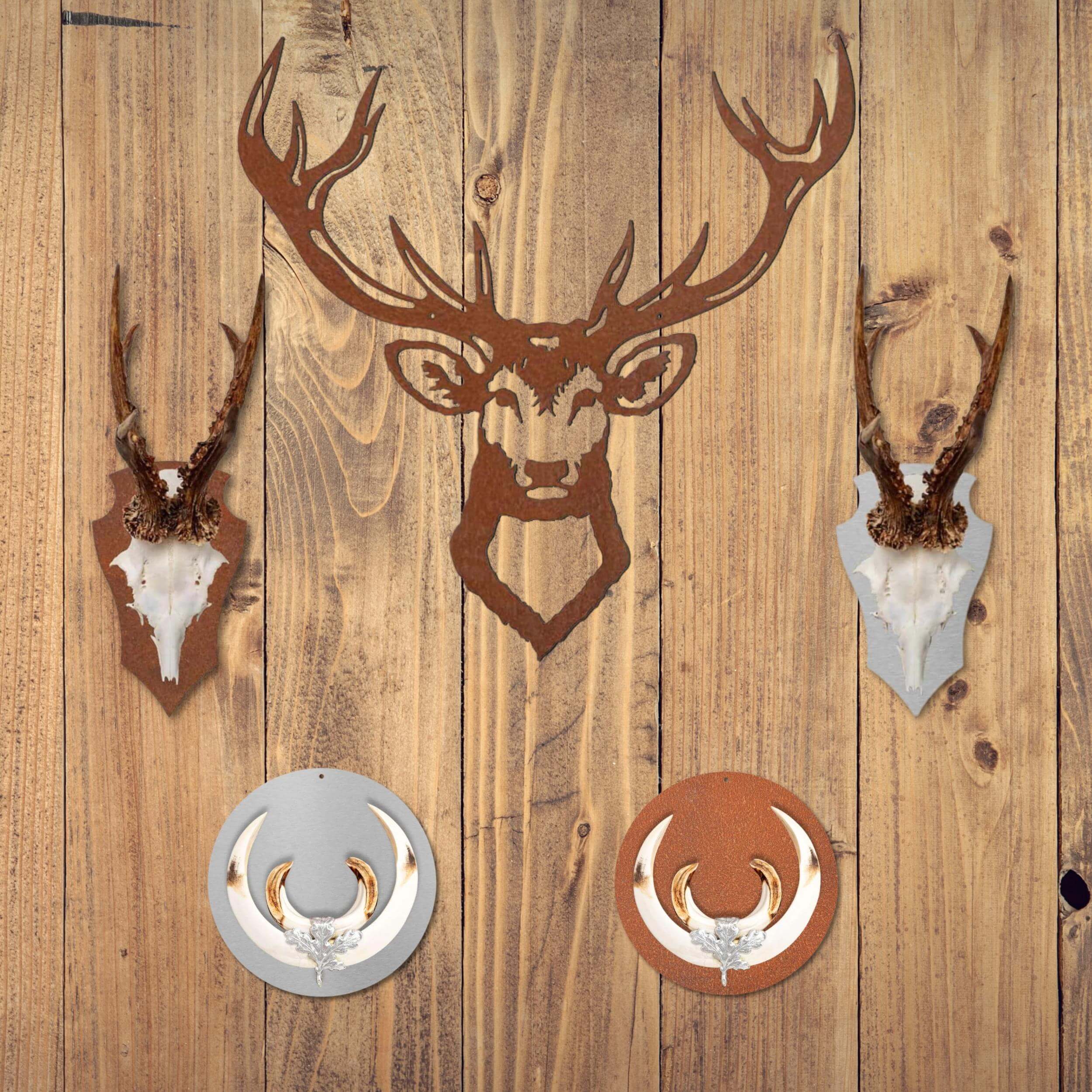 Es hängen Gehörnbretter mit Gehörn sowie Keilerbretter und ein Wandbild aus Stahl in Form eines Hirsches an einer hölzernen Wand.